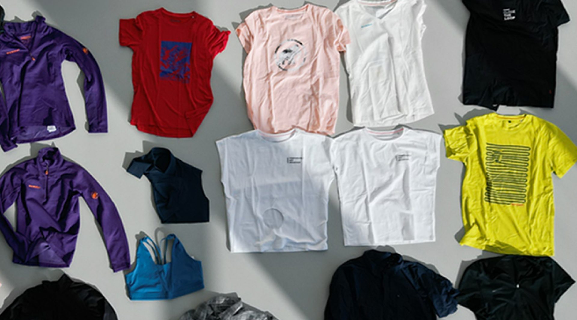 Kleidungsstücke liegen zusammengefaltet auf dem Boden.