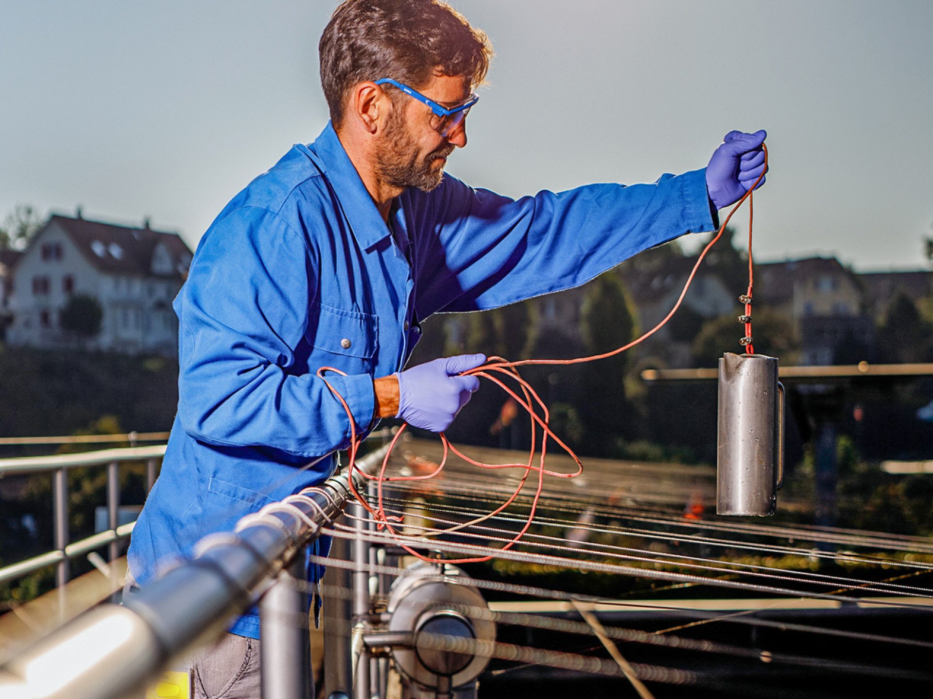 Ein Mann in Schutzkleidung hantiert in Schutzkleidung mit Gerätschaften in der Kanalisation