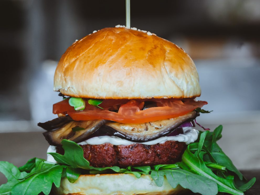 Ein Burger belegt mit Gemüse und einem Patty.