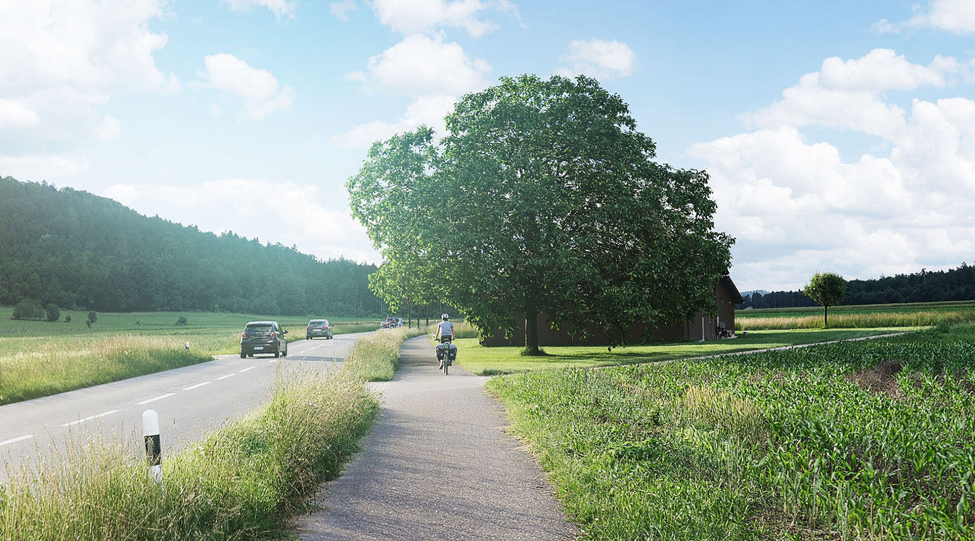 Auf einer Landstrasse sind Autos und ein Velofahrer unterwegs.