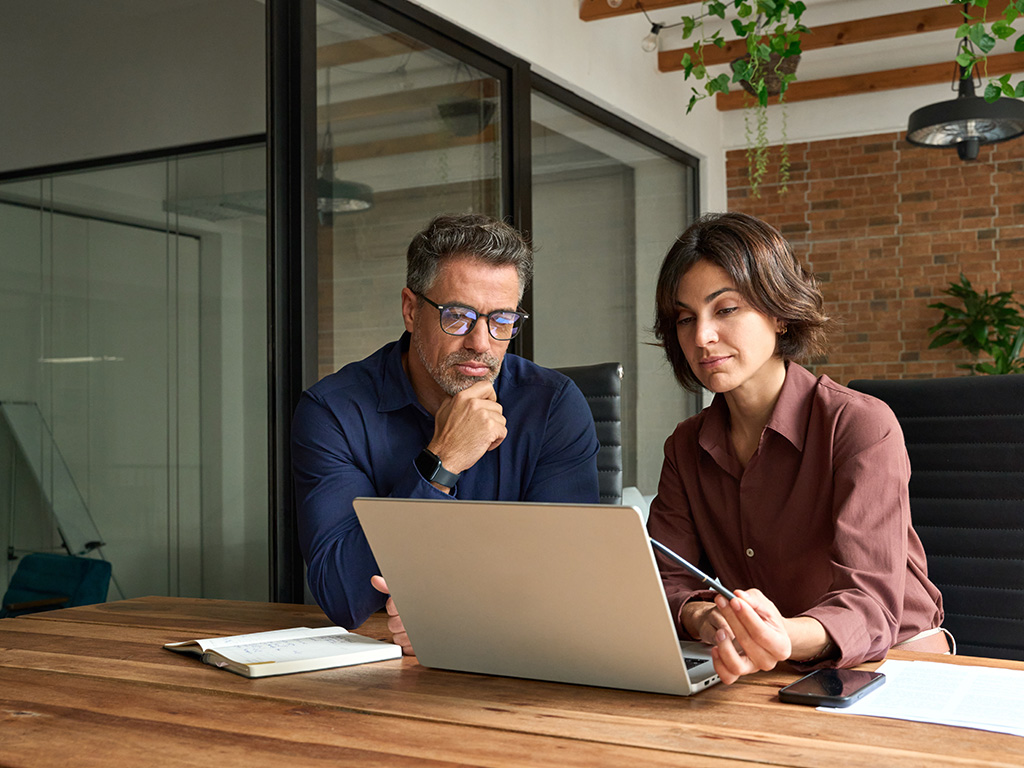 Ein Mann und eine Frau sitzen am Laptop.