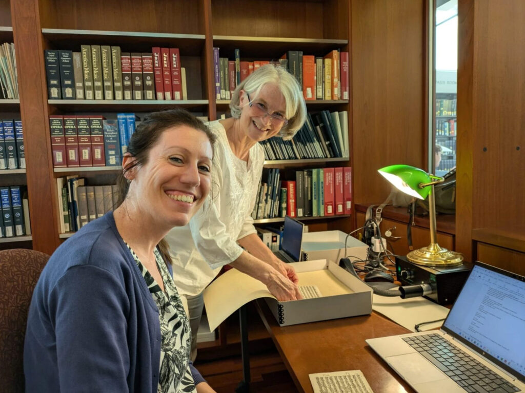 Agnese Pavanello und Cristina Cassia an einem Schreibtisch mit Laptop und Dokumenten.